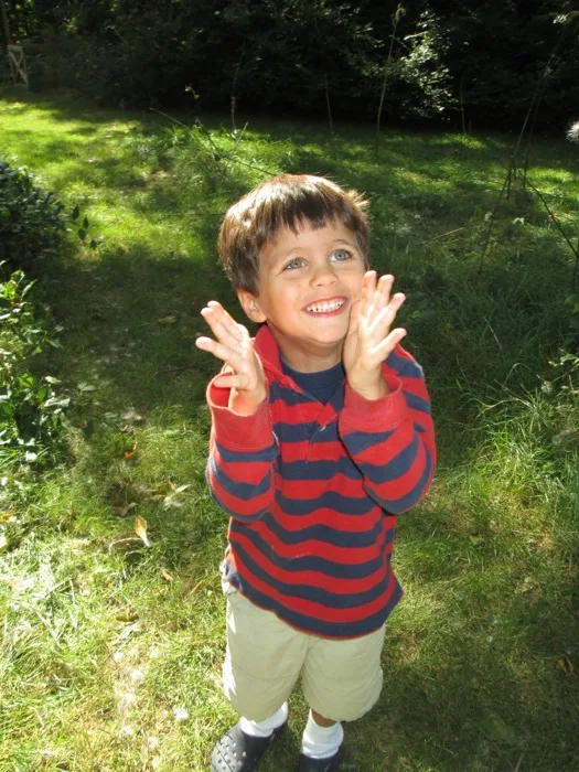Child beaming with joy in the sunny school garden