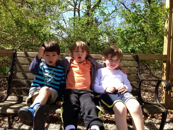 Three friends relaxing together on an outdoor bench