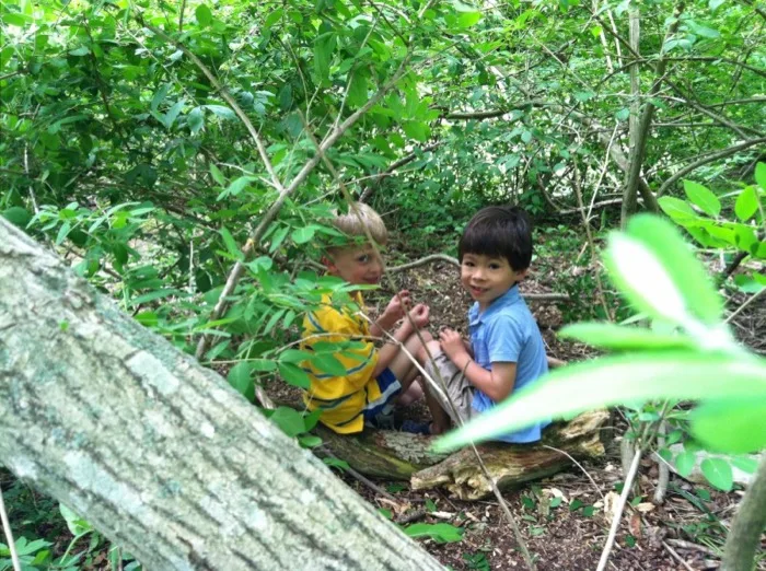Two boys exploring the wooded paths behind the school