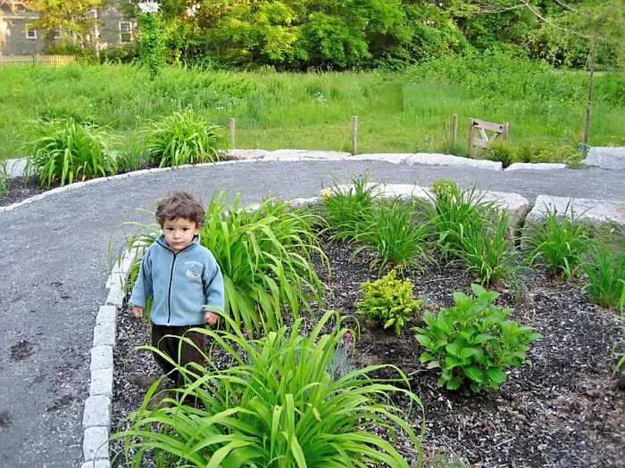 Toddler exploring the school's beautiful spiral garden path
